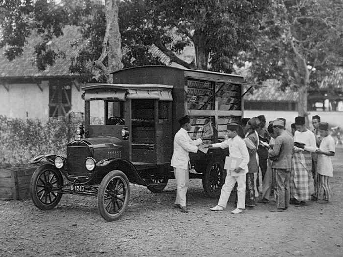 Volkslectuur ‘Reizende bibliotheek’, vermoedelijk jaren ’30, fotograaf onbekend. De reizende bibliotheek was een onderdeel van Balai Poestaka, het Nederlands-koloniaal initiatief om de Indonesiërs aan ‘goede’ boeken te helpen. De foto laat zien hoe drukwerk destijds werd verspreid en hoe het boek ook op plaatsen kwam waar geen boekwinkels waren.